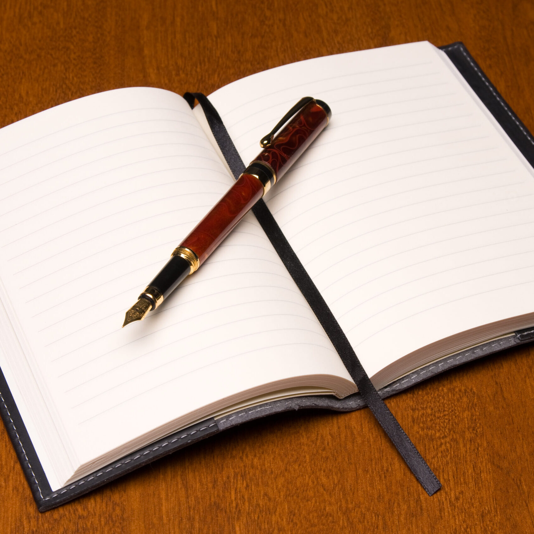 Small leather-bound journal and fountain pen.